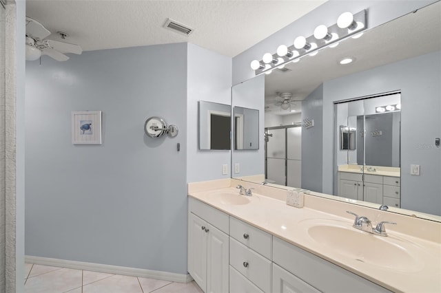 bathroom with ceiling fan, vanity, tile patterned flooring, and a textured ceiling