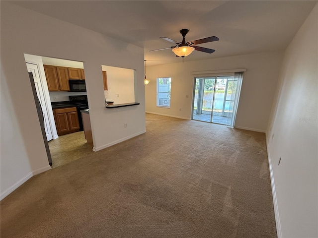 unfurnished living room featuring baseboards, a ceiling fan, and light colored carpet