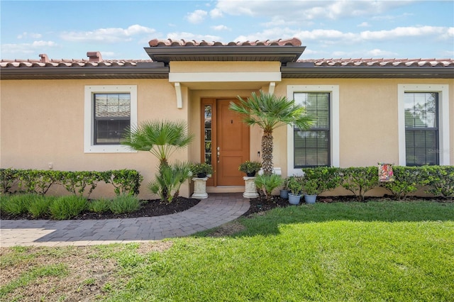 doorway to property featuring a lawn