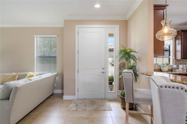 foyer featuring ornamental molding and light tile patterned flooring