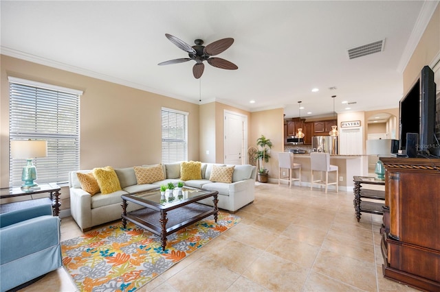 tiled living room with ceiling fan, plenty of natural light, and crown molding