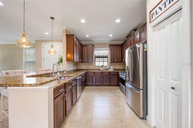 kitchen featuring a breakfast bar, hanging light fixtures, light stone countertops, appliances with stainless steel finishes, and a healthy amount of sunlight