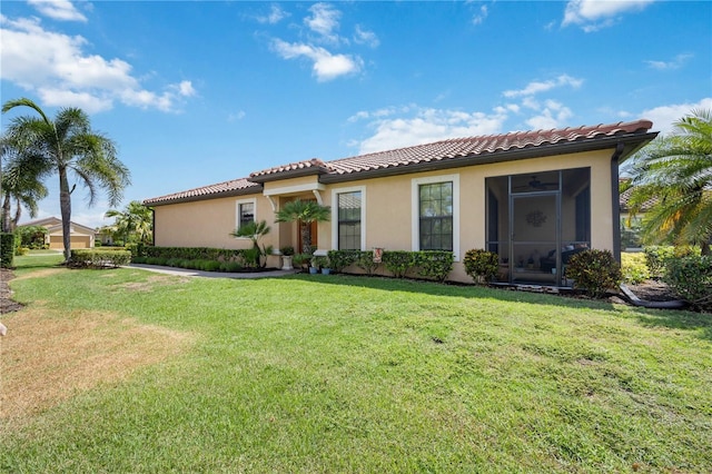 mediterranean / spanish house with a front yard and a sunroom