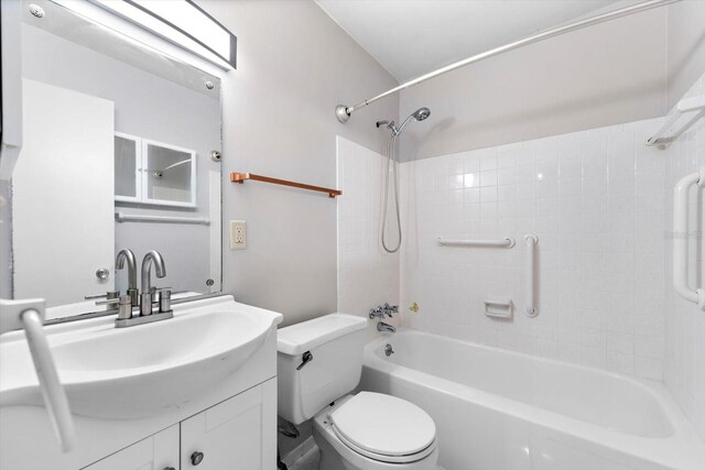 full bathroom with tiled shower / bath combo, vanity, and toilet