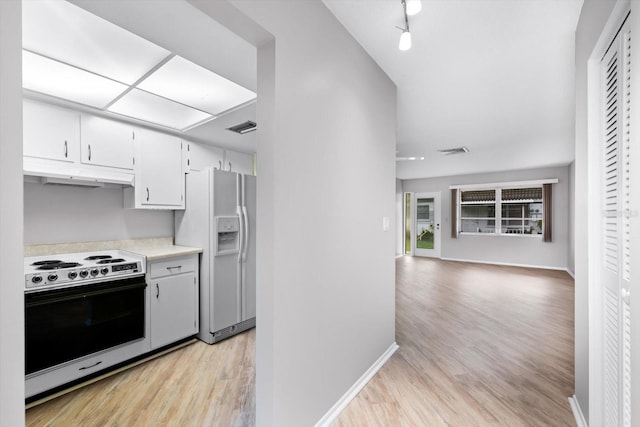 kitchen featuring white fridge with ice dispenser, white cabinets, light wood-type flooring, and range