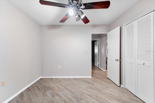 unfurnished bedroom with light hardwood / wood-style flooring, a closet, and ceiling fan