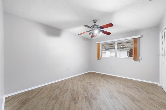 spare room with ceiling fan, a textured ceiling, and light hardwood / wood-style floors