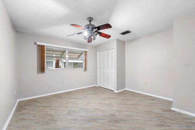 unfurnished room featuring ceiling fan, a textured ceiling, and light hardwood / wood-style floors