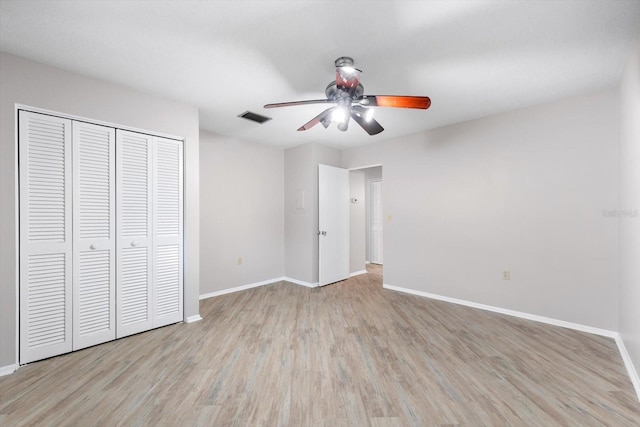 unfurnished bedroom with a closet, light hardwood / wood-style floors, and ceiling fan