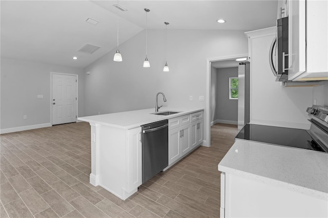 kitchen featuring white cabinetry, hanging light fixtures, lofted ceiling, stainless steel appliances, and sink