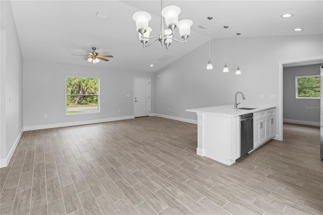 kitchen with hanging light fixtures, sink, vaulted ceiling, and light hardwood / wood-style floors