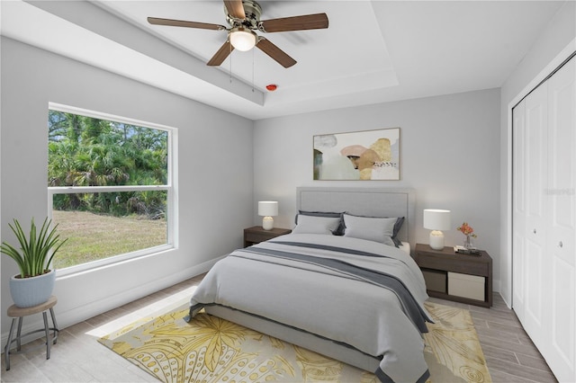 bedroom featuring ceiling fan, multiple windows, and a closet