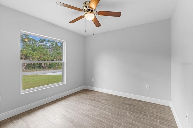 empty room featuring ceiling fan, light hardwood / wood-style flooring, and a wealth of natural light