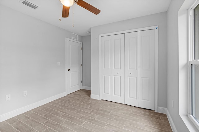 unfurnished bedroom with ceiling fan and a closet