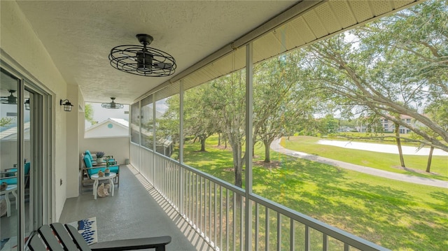 unfurnished sunroom with ceiling fan