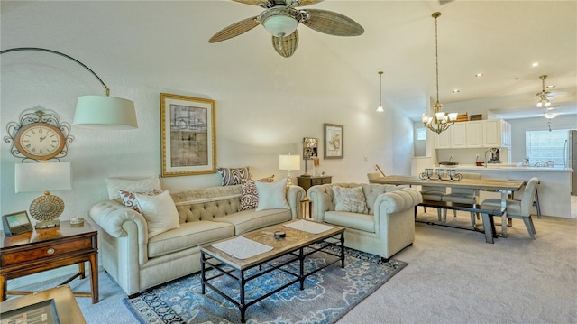 carpeted living room with ceiling fan with notable chandelier