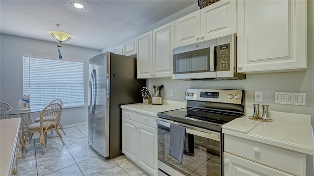 kitchen with white cabinets, light tile floors, and stainless steel appliances