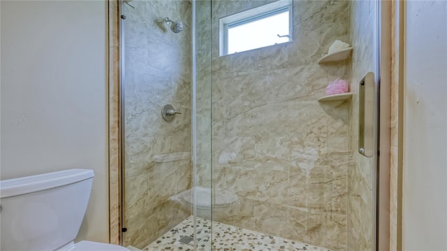 bathroom with a shower with shower door and toilet