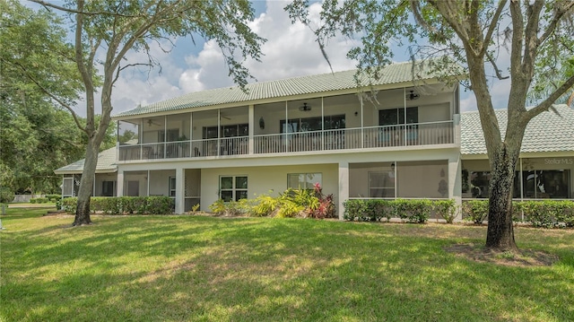 back of house featuring a balcony and a yard