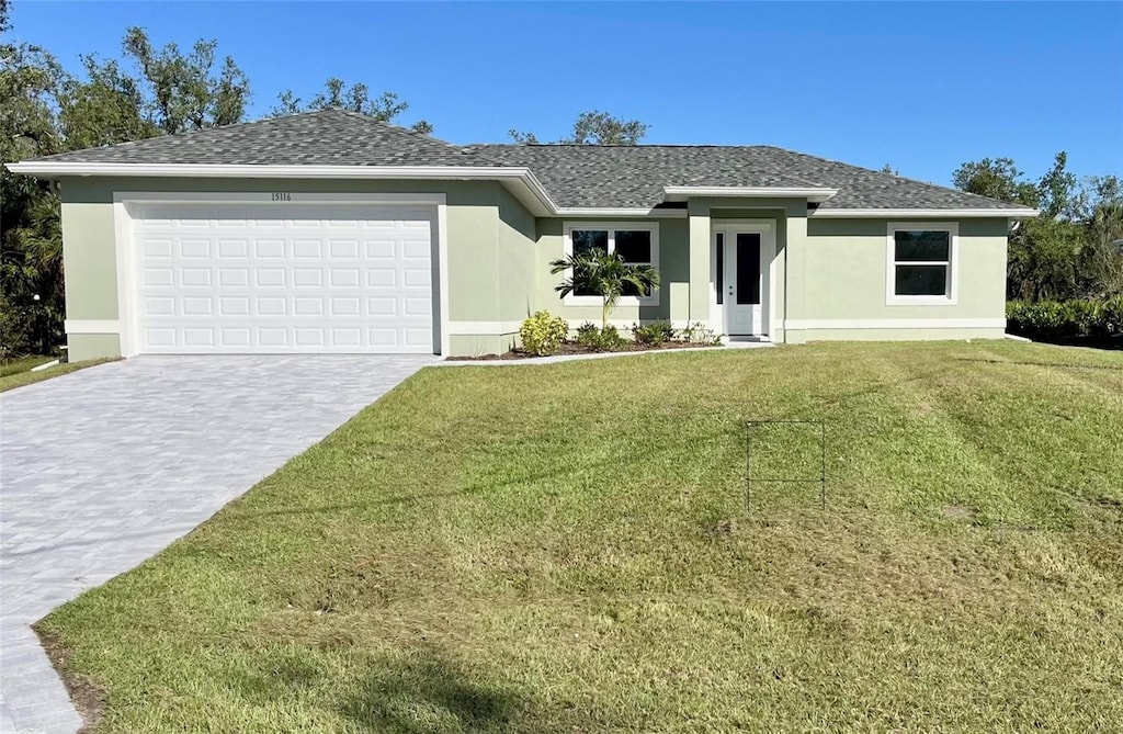 view of front of property with a garage and a front lawn