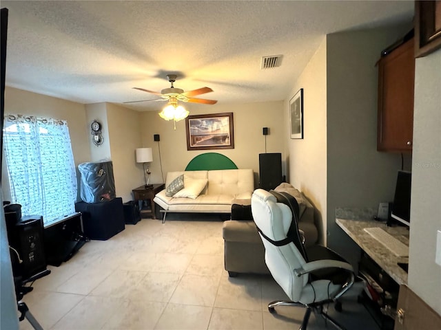 bedroom with ceiling fan, a textured ceiling, and light tile flooring