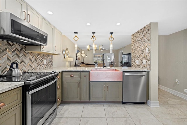 kitchen featuring appliances with stainless steel finishes, pendant lighting, sink, tasteful backsplash, and light tile flooring