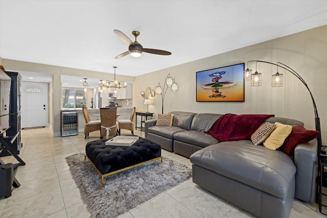 living room with ceiling fan with notable chandelier, beverage cooler, and light tile floors