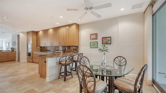 dining area with sink and ceiling fan