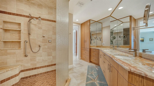 bathroom with vanity and tiled shower