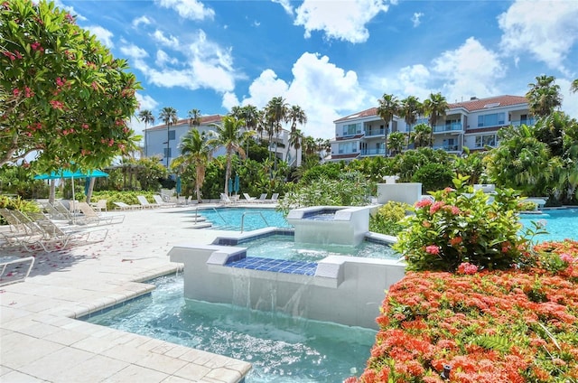 view of swimming pool with pool water feature and a jacuzzi