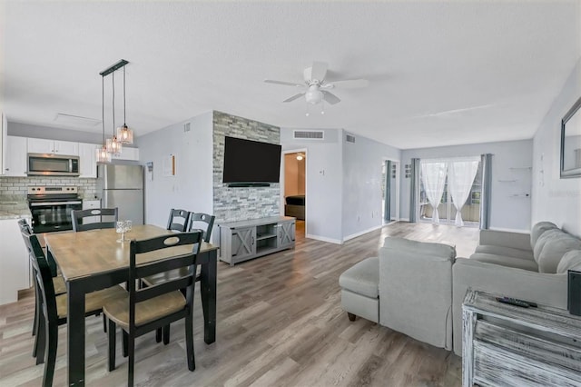 dining space featuring a textured ceiling, ceiling fan, and light hardwood / wood-style floors