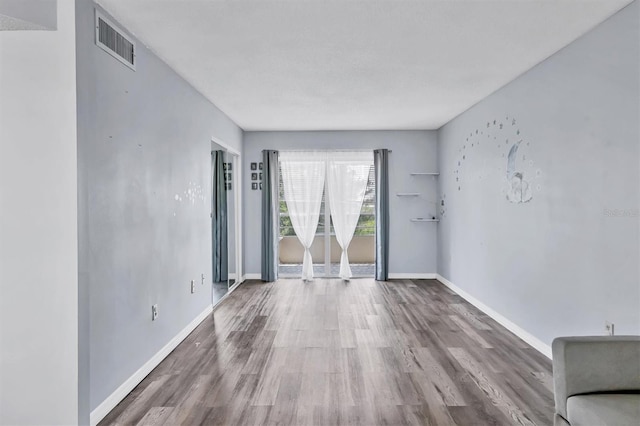 unfurnished room with hardwood / wood-style flooring