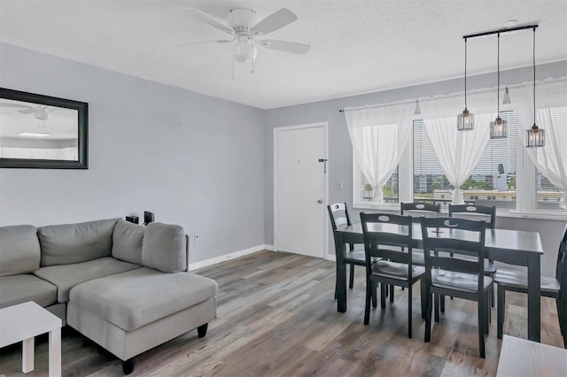 dining area with hardwood / wood-style flooring, a textured ceiling, and ceiling fan