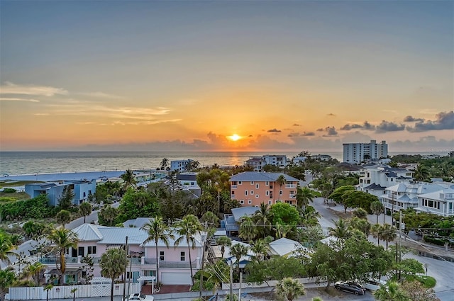 aerial view at dusk featuring a water view