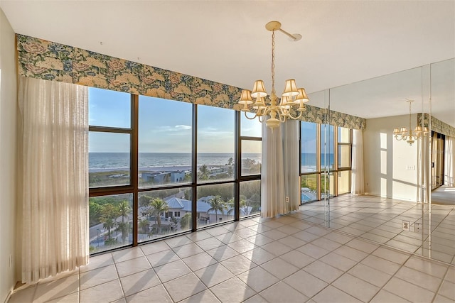 spare room featuring a water view, a notable chandelier, tile patterned floors, and floor to ceiling windows