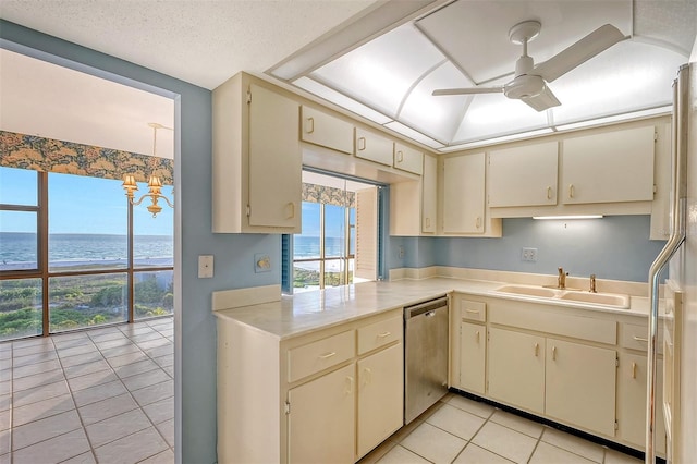 kitchen with a water view, stainless steel dishwasher, and cream cabinets