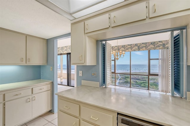 kitchen with a water view, cream cabinetry, plenty of natural light, and dishwasher