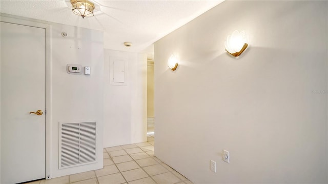 hallway featuring light tile patterned flooring and a textured ceiling