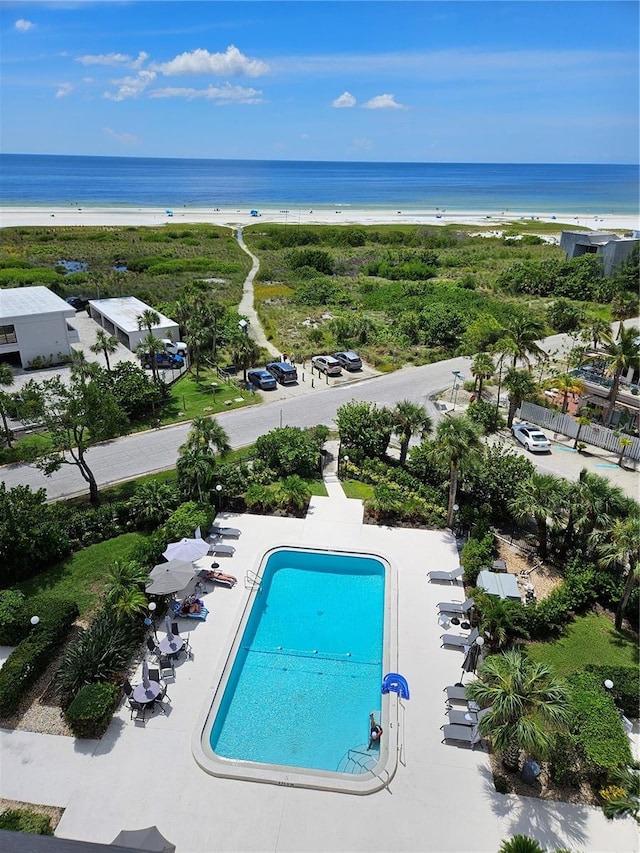 view of pool featuring a water view and a view of the beach