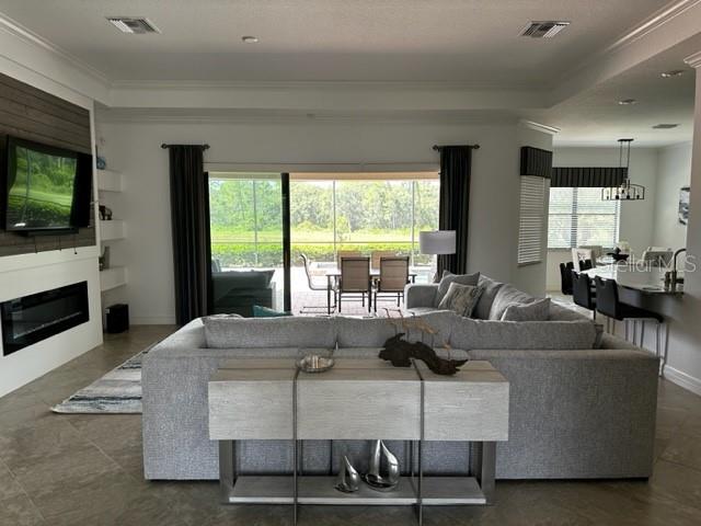 living room with a raised ceiling and crown molding