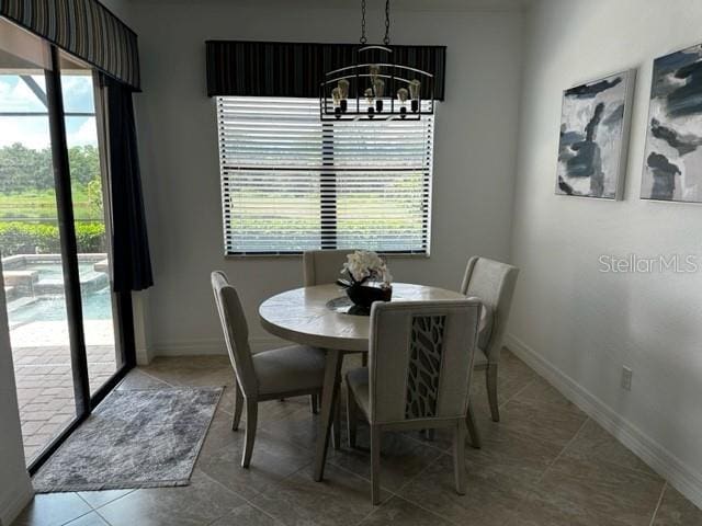 tiled dining area with a chandelier