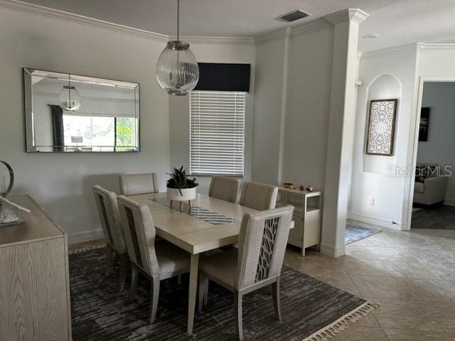 dining space featuring tile patterned floors and crown molding