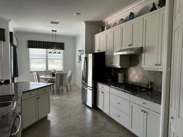 kitchen with white cabinets, tasteful backsplash, hanging light fixtures, and dark stone countertops