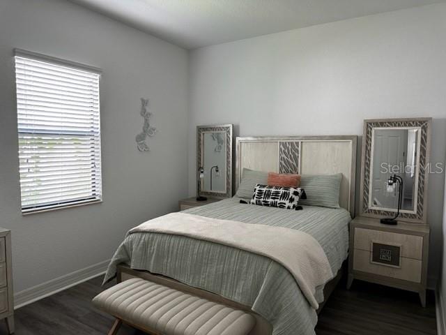 bedroom with dark wood-type flooring