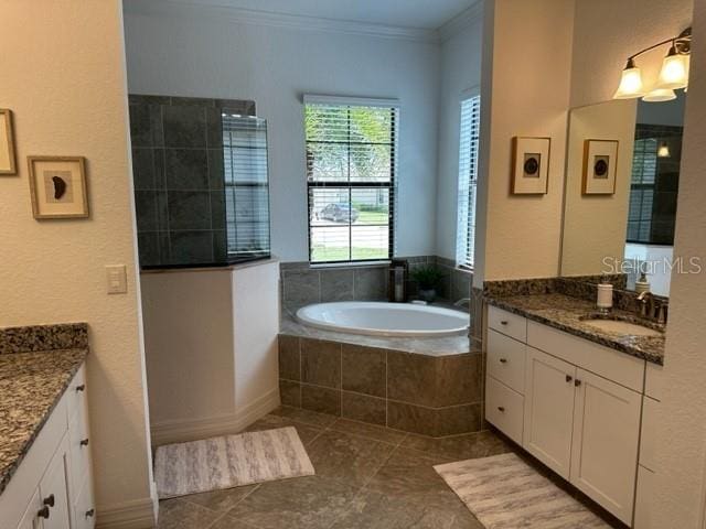 bathroom featuring tile patterned floors, tiled tub, vanity, and ornamental molding