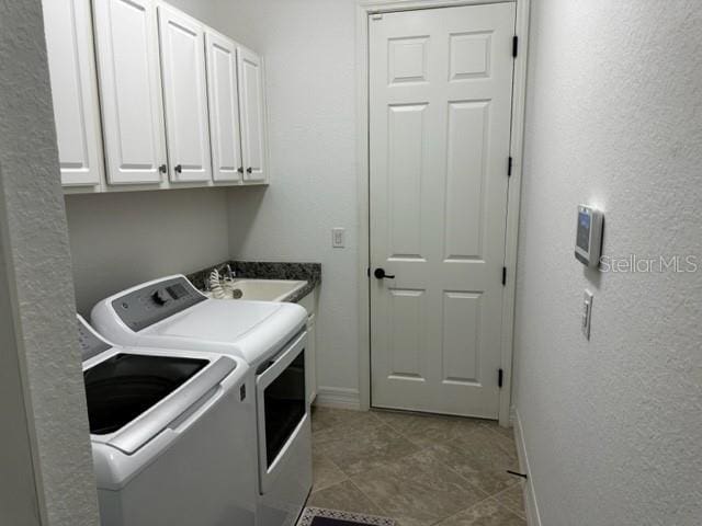 laundry area featuring cabinets, separate washer and dryer, and sink