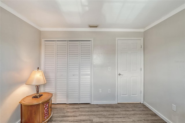 bedroom featuring crown molding and wood-type flooring