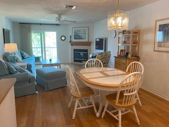 dining room featuring a textured ceiling, ceiling fan with notable chandelier, and hardwood / wood-style floors