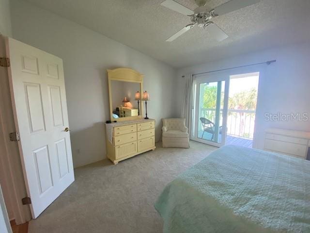 bedroom with a textured ceiling, ceiling fan, light colored carpet, and access to exterior