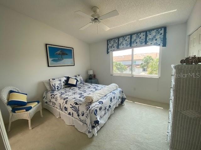 bedroom with a textured ceiling, carpet, and ceiling fan